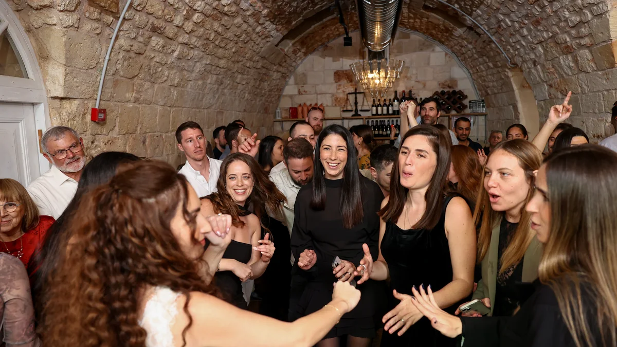 רחבת הריקודים רחבת ריקודים מלאה באורחים בתוך חלל קמרונות אבן בסוף הערב