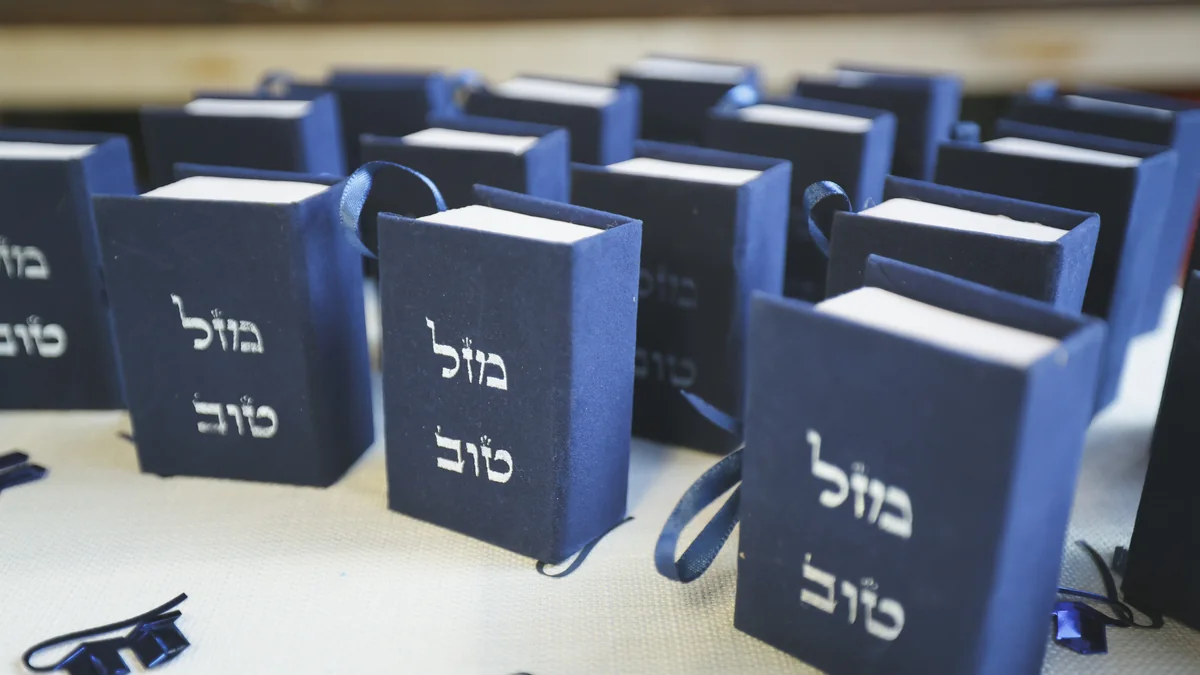 שורת שקיות מתנה כחולות עם הכיתוב מזל טוב ערוכות על שולחן